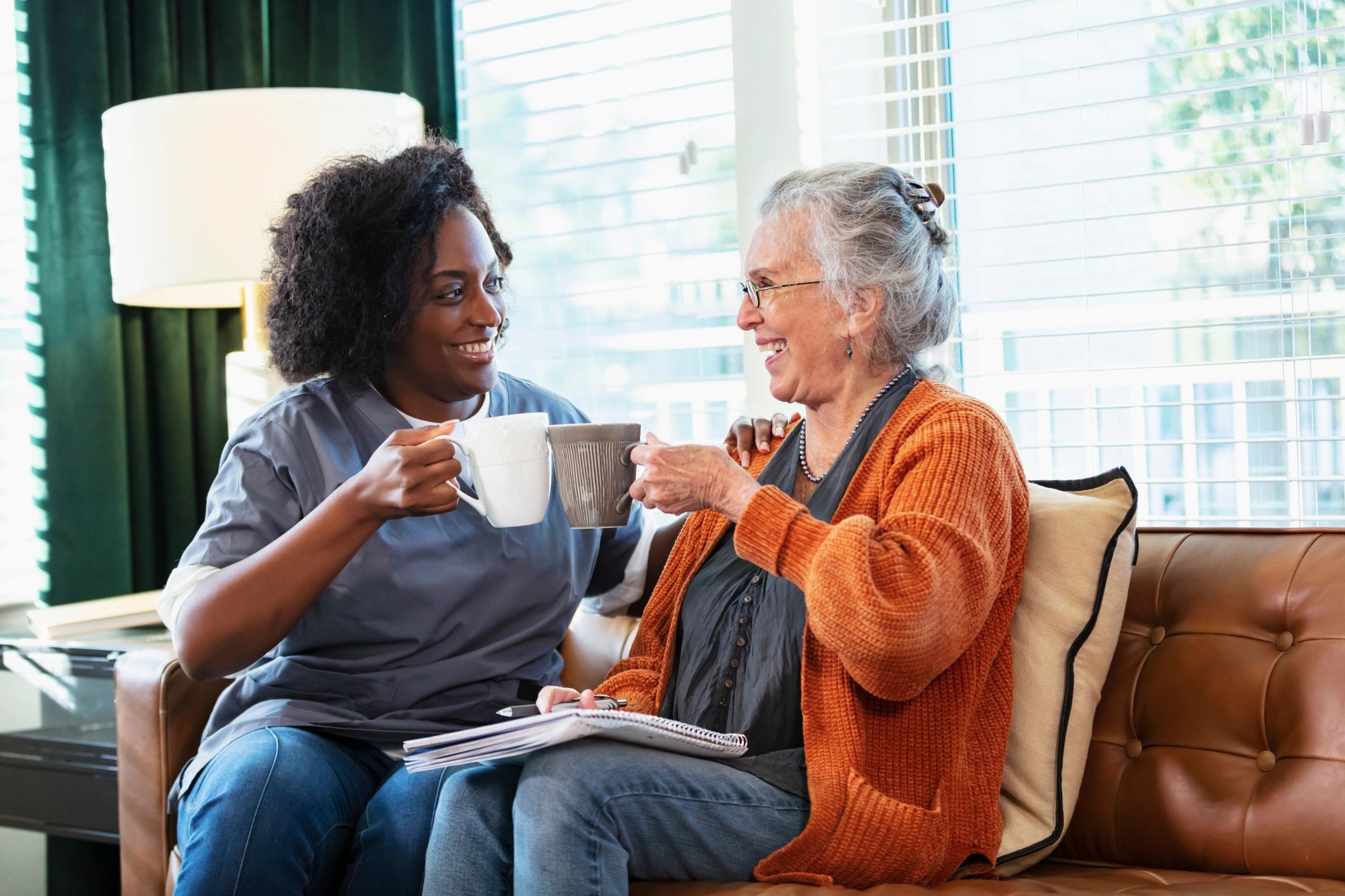 Senior woman sharing coffee with a caregiver